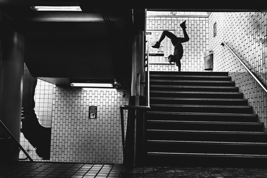A silhouette of a woman doing a handstand at the top of some stairs in philadelphia.